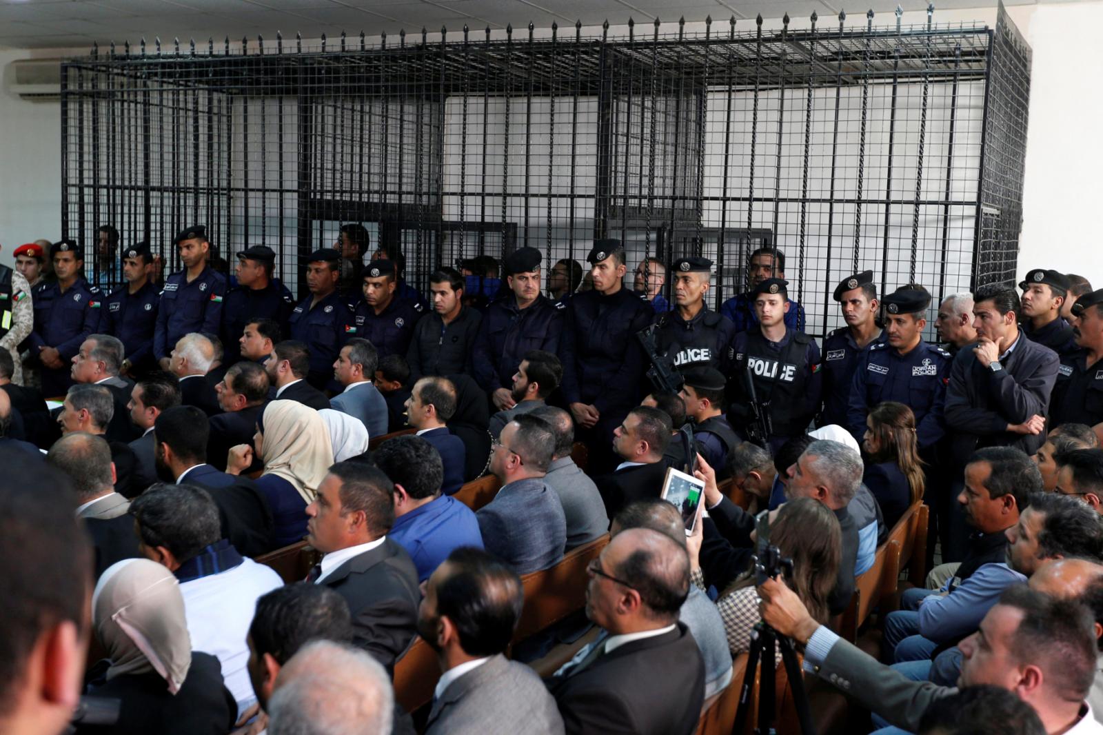 The businessmen and customs officials charged with tax evasion are seen behind bars at the State Security Court in Amman, Jordan, on March 12, 2019. REUTERS/Muhammad Hamed 