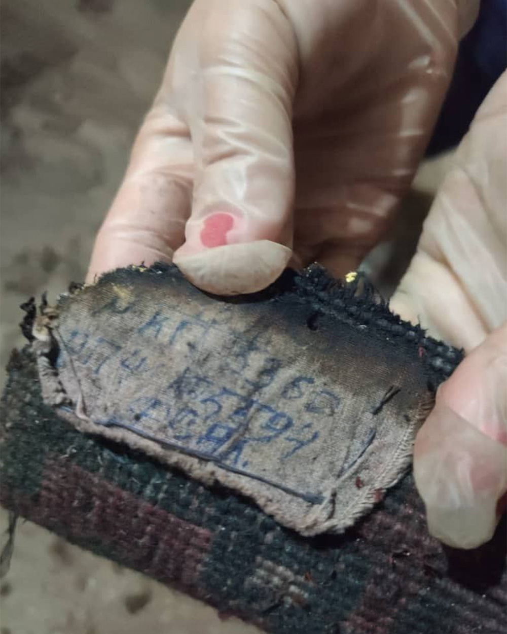 A museum worker holding a damaged artifact