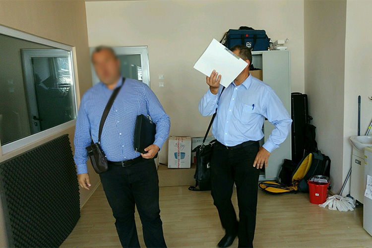 Offices from the Romanian Anti-Fraud Authority at the offices of RISE Project, OCCRP's Romanian partner, during a surprise inspection. (Photo: RISE Project)