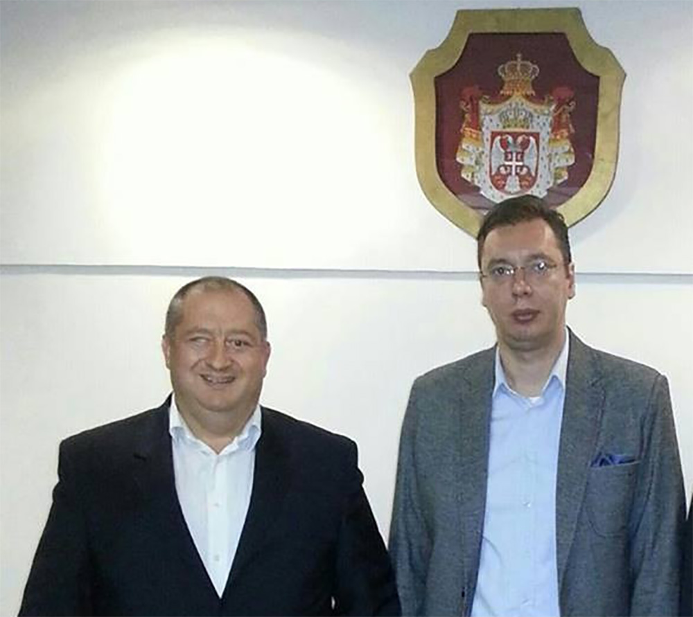 Serbian President Vucic with Petar Panic in front of the Serbian Coat of Arms. According to Panic’s caption, the photo was taken in 2013, when Vucic was First Vice President and Minister of Defence. (Photo: Facebook) 