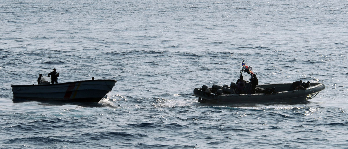 Colombian navy sailors in a patrol boat, left, and Sailors and Coast Guardsmen from the littoral combat ship USS Freedom search for illicit drugs dumped overboard by the crew of a high-speed "go-fast" vessel. (Photo: US Navy)