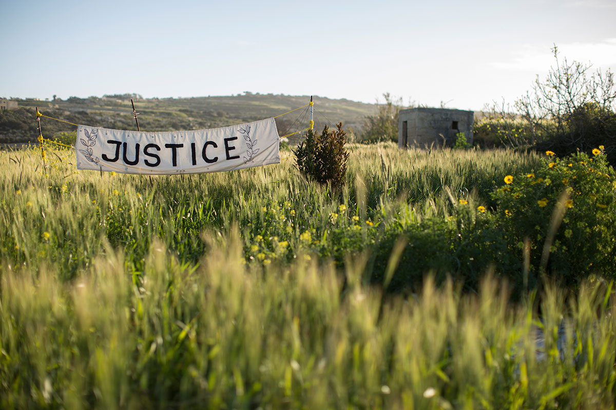A banner in the fields outside Bidnija, where investigative journalist Daphne Caruana Galizia was murdered six months ago. Photo (c): Dan Kitwood