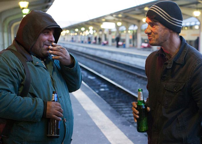 Two men drink beer at a railway station in Romania’s capital, Bucharest.